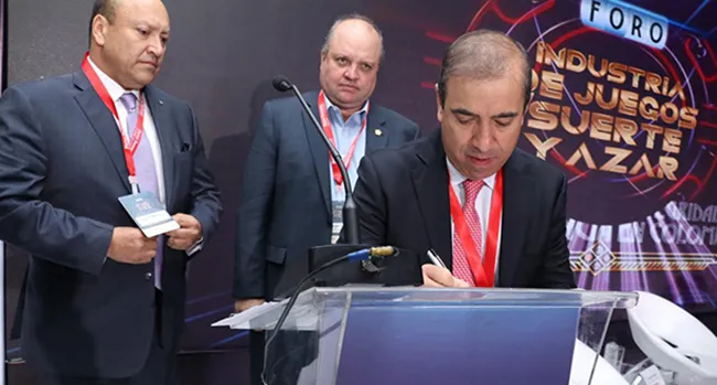 Evert Montero, presidente de Fecoljuegos, y Jorge Enrique Vélez, presidente de la Dimayor. Firmando, Juan Carlos Restrepo, presidente de Asojuegos